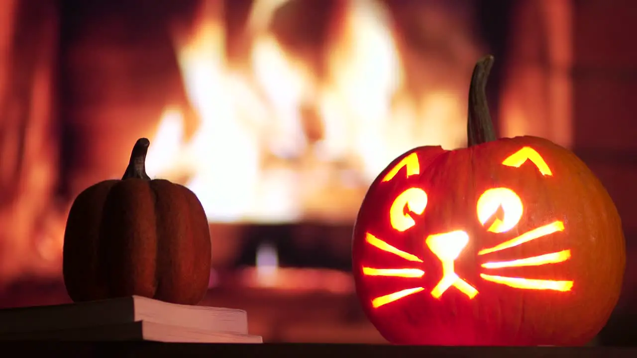 A carved pumpkin for Halloween in front of a fire