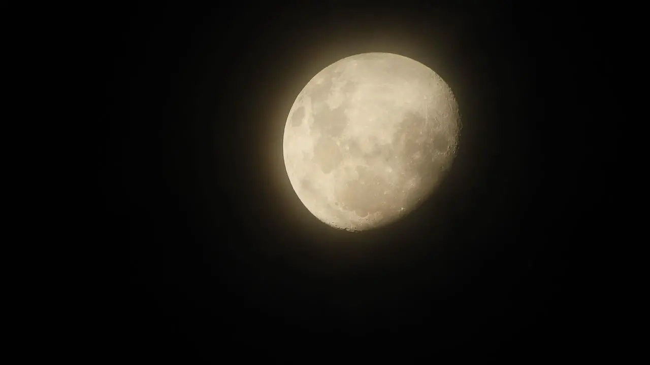 Haunted creepy near full moon with eerie dark clouds moving past in the foreground perfect for Halloween scary dark themed celestial footage