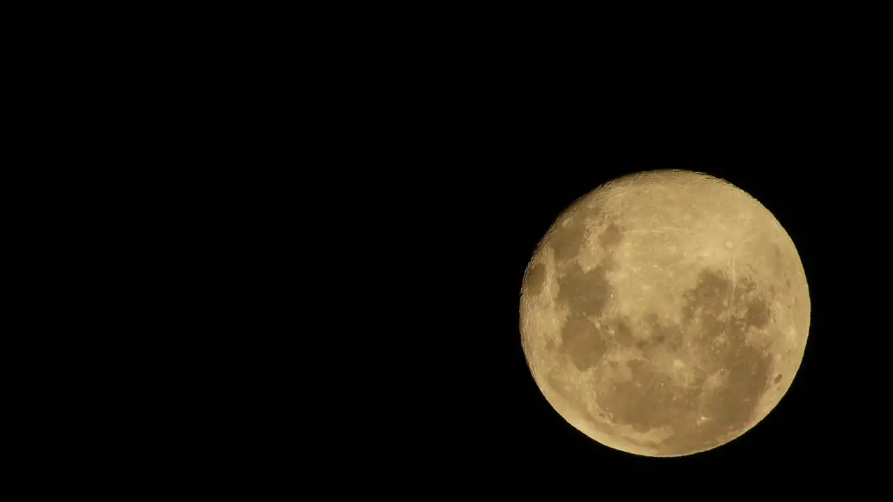 Haunted creepy reddish full moon moving past in the night sky perfect for halloween scary dark theme celestial footage