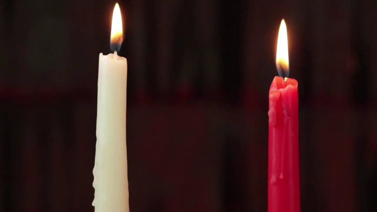 Two burning candles white and red steadycam