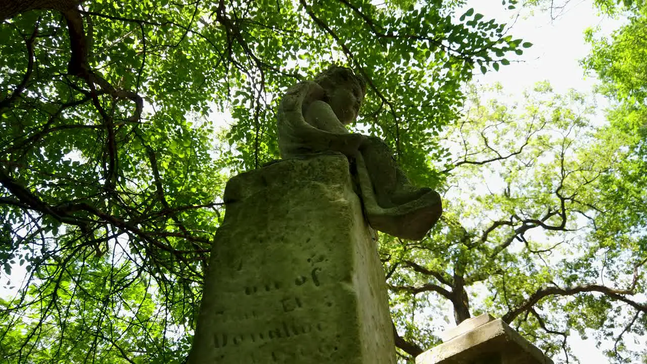 Angel tombstone in an old overgrown abandoned eerie cemetery