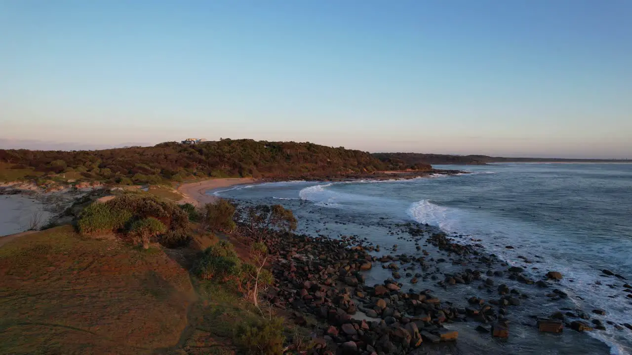 Waves Splashing On Rocky Shore At Sunrise