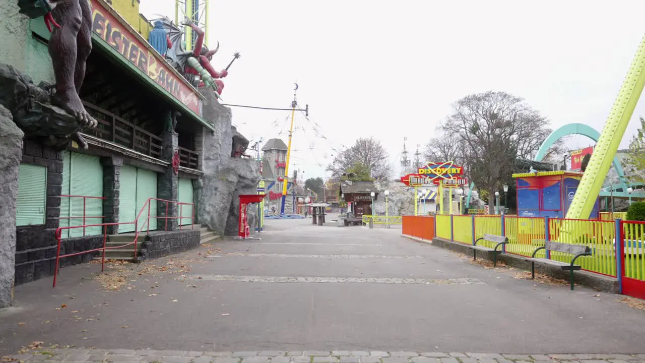 empty street in usually crowded area in fun park next to a fake haunted house during lockdown slow motion