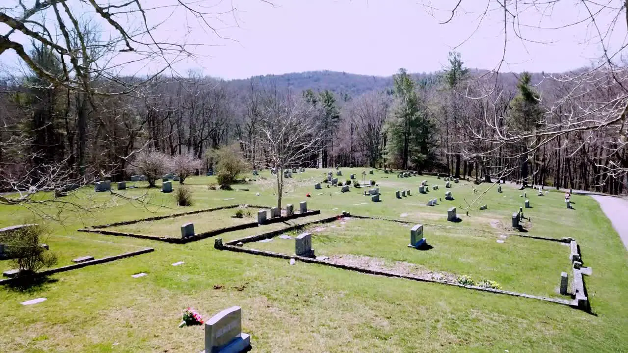 Tombstones through tree branches aerial in nc graveyard and cemetery