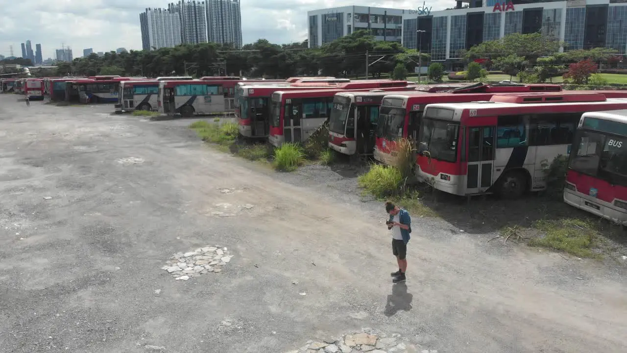 Man standing at old busses junkyard at Kuala lumpur aerial