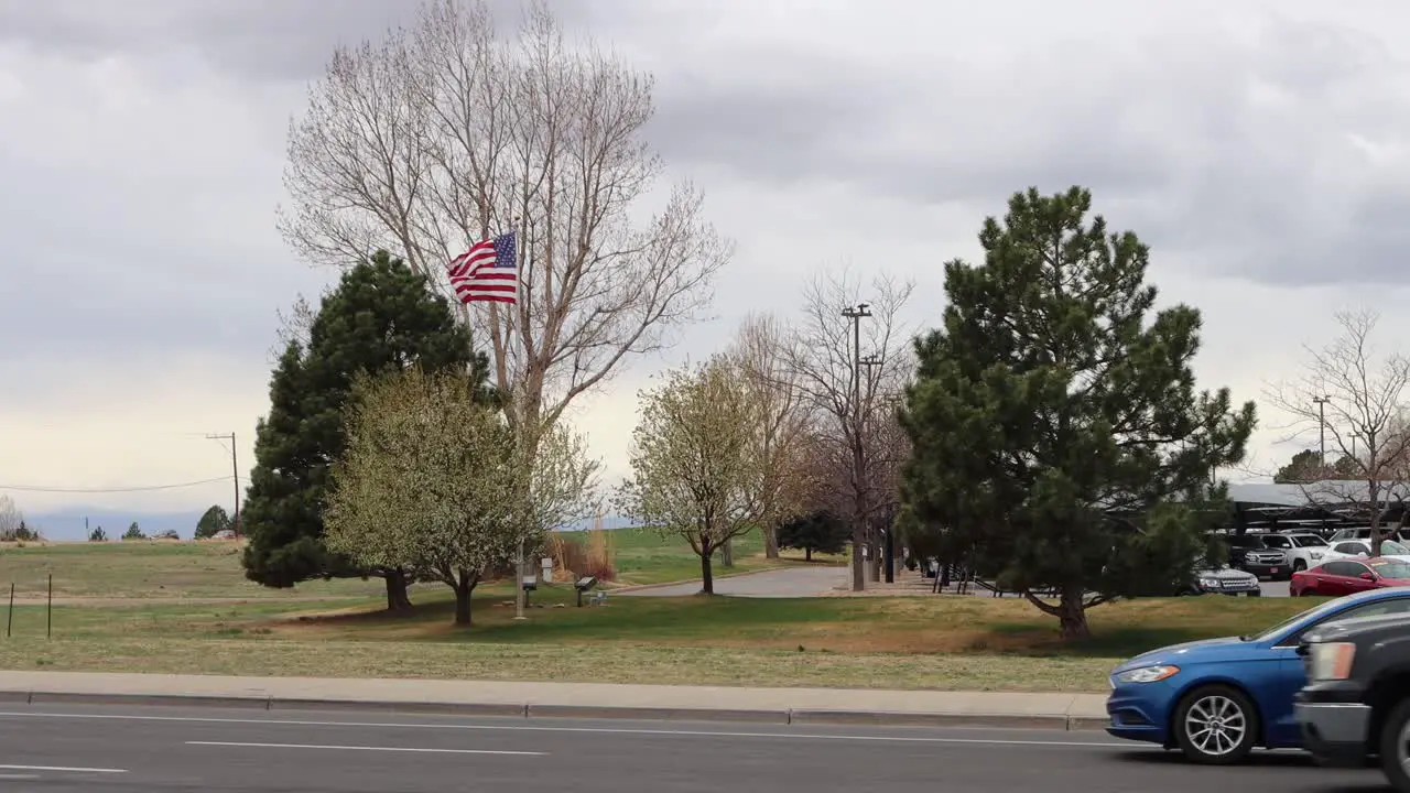 American flag blowing in extreme wind traffic blowing trees