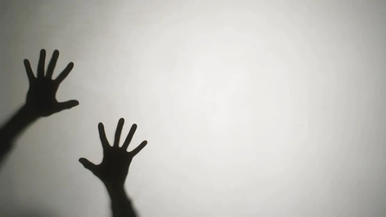 Video of silhouettes of hands moving on white background