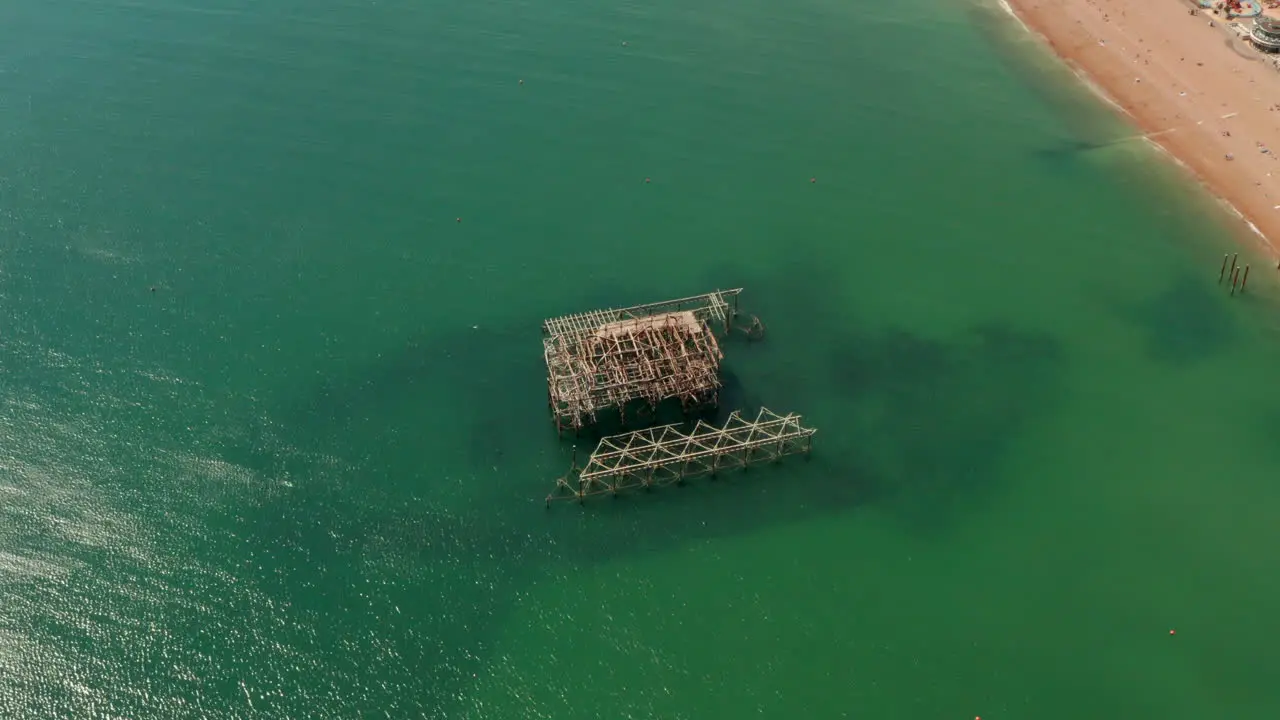 High circling aerial shot over old burned Brighton Pier