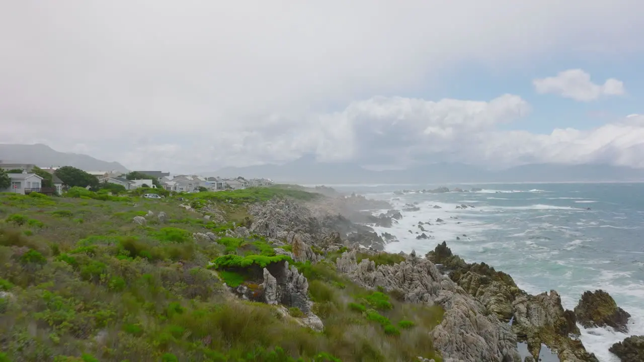 Forwards fly above rugged sea coast Waves rolling to coastal rocks and splashing to height