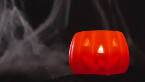 Halloween Pumpkin Jack-O-Lantern With Candle Against Black Background With Cobwebs