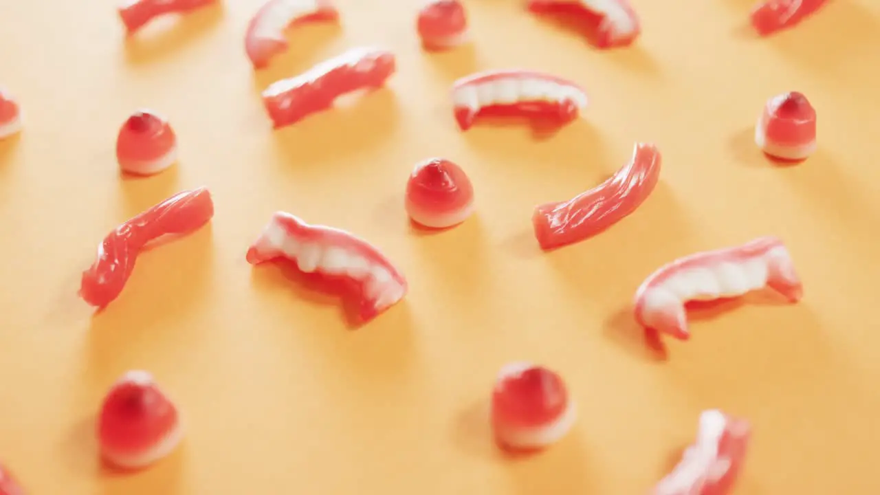 Close up of multiple halloween candies fallen against orange background