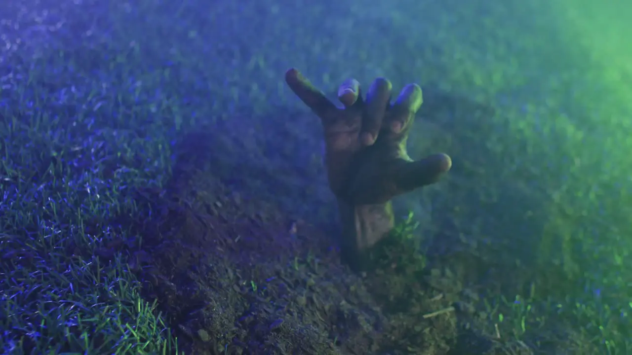 Video of hand raising from grass on black background