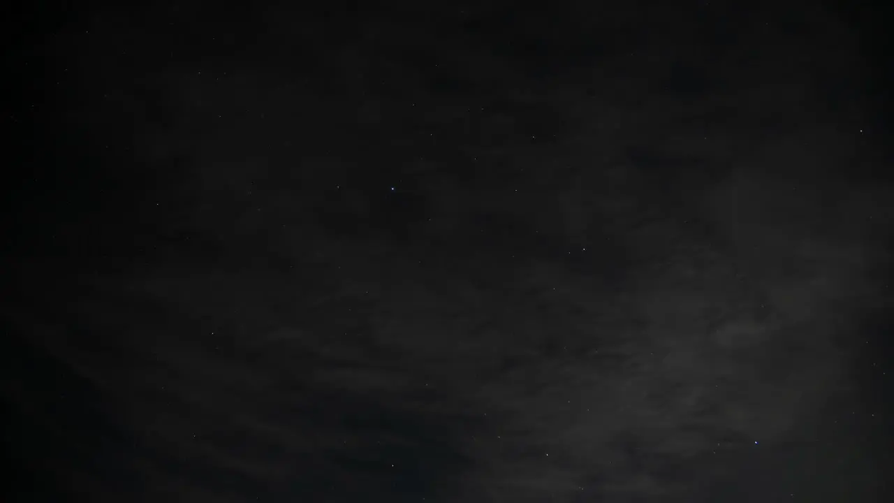 Time Lapse of clouds rolling by to reveal a starry night wide 4K