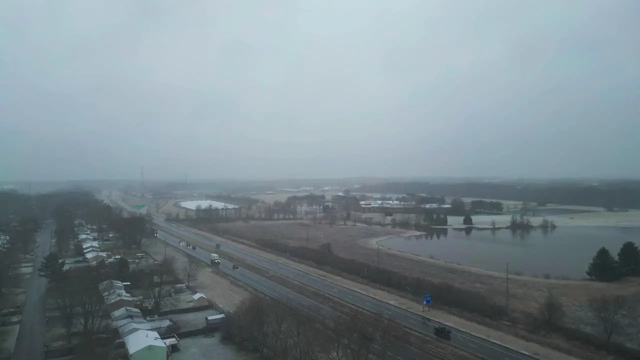 Flying Over Main Road Near Beautiful Lake In Snowy Weather In Warren Ohio USA