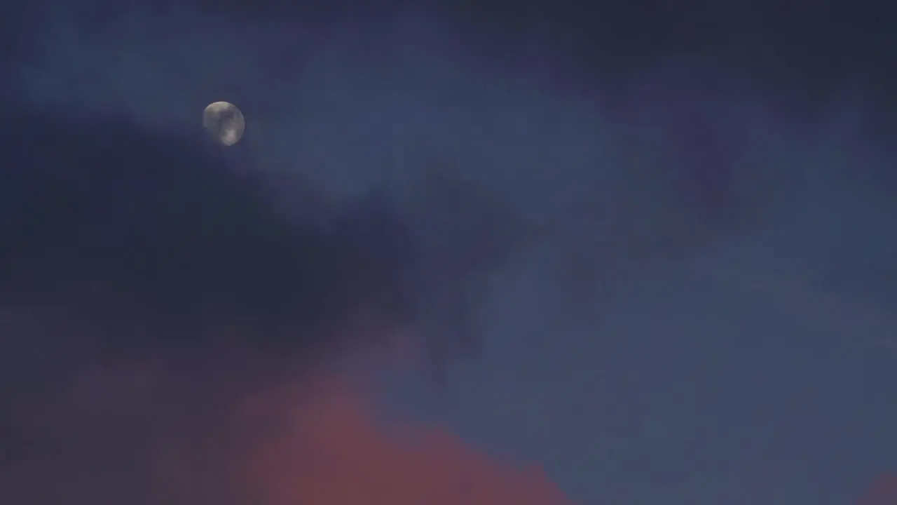 Dark Colorful Clouds Billow Across Sky With Full Moon