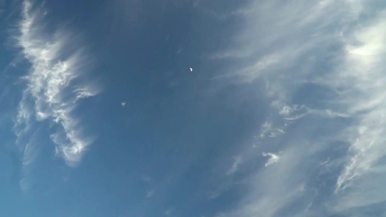 View of Beautiful mysterious blue sky with fading clouds and moon with slow handheld camera movement SLOW MOTION