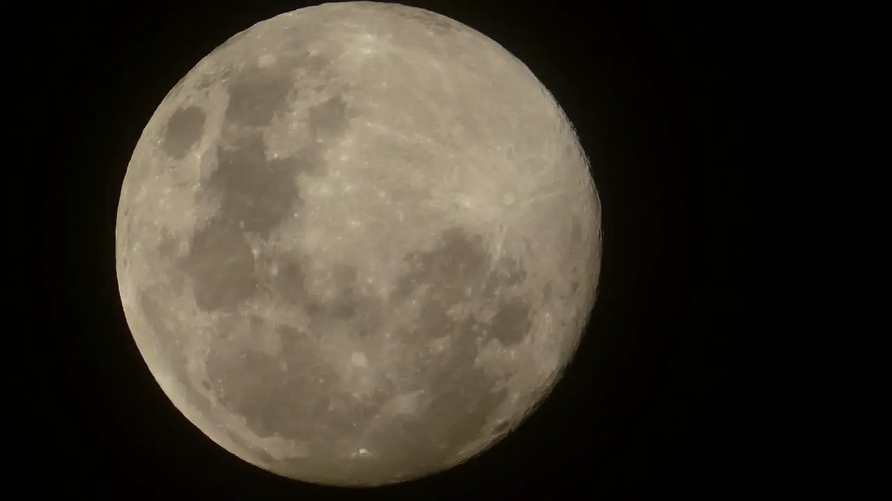 Timelapse of a full moon slowly rising in the night sky