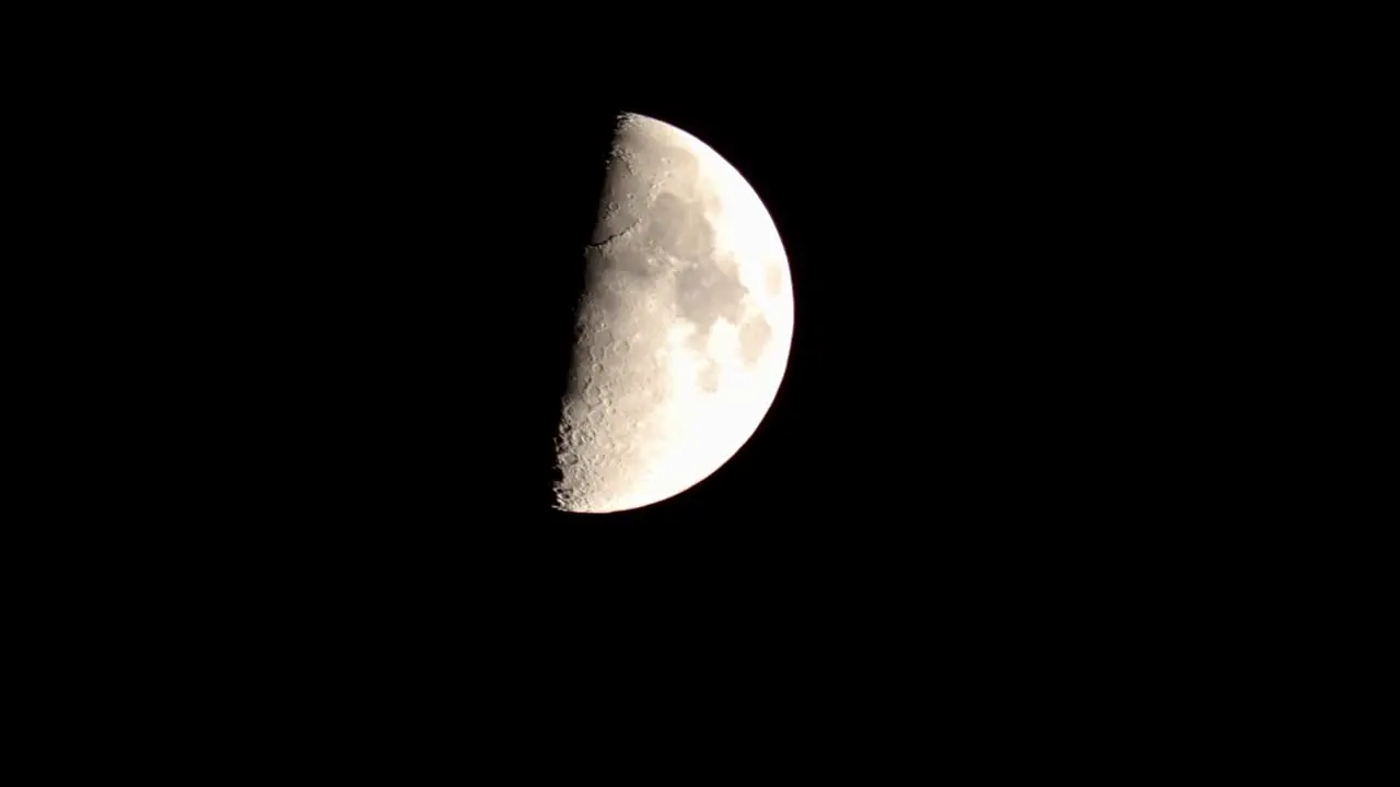 Nightime closeup of quarter moon descending against a black sky