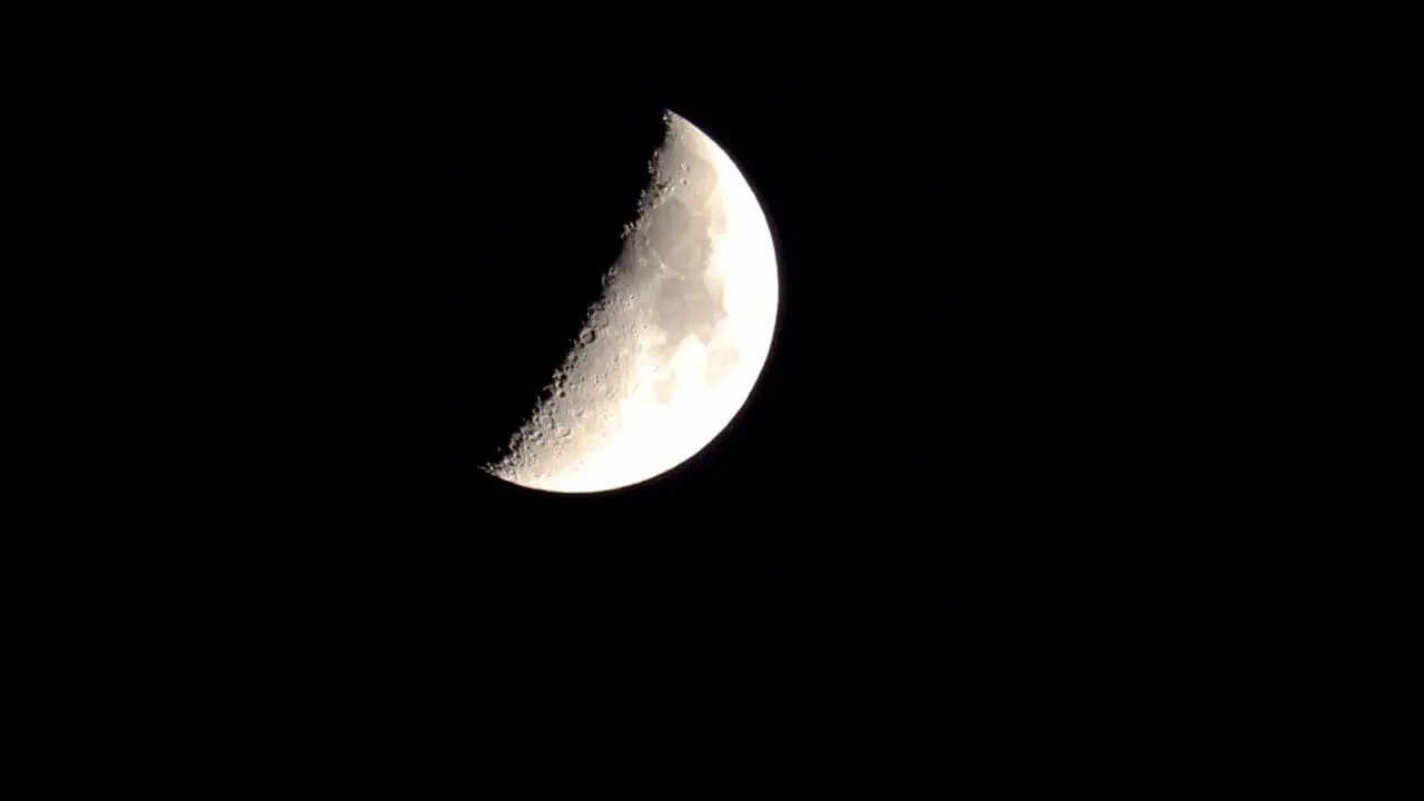 Closeup of quarter moon descending on the screen at night