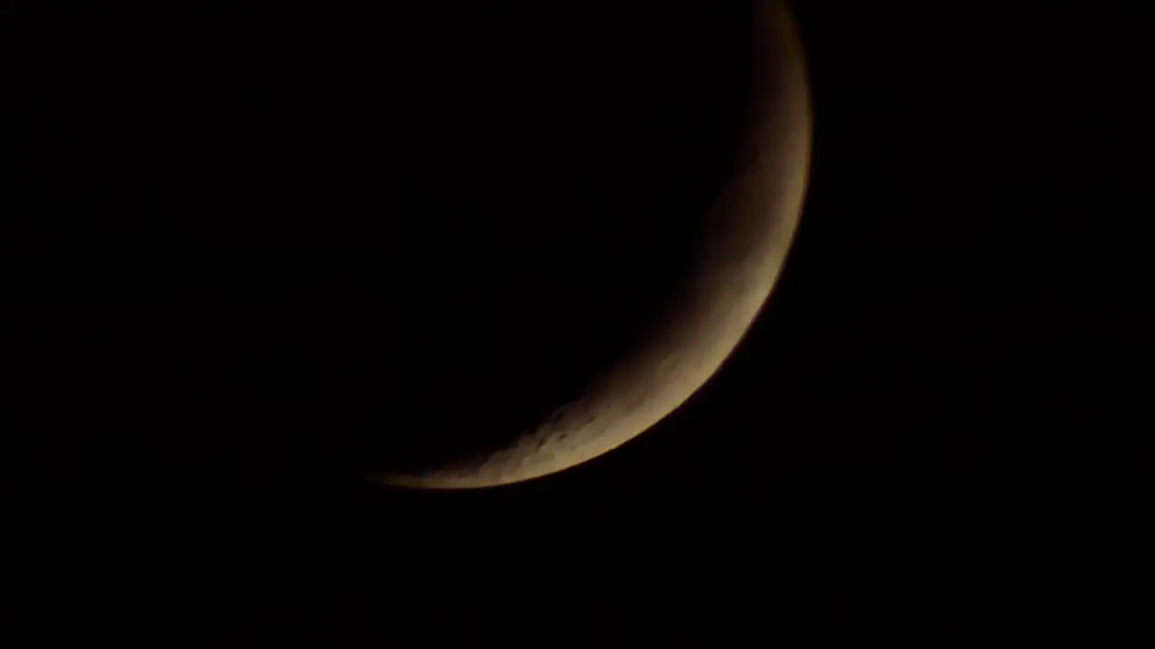 Dark dramatic bright glowing moon with fast moving storm clouds passing across