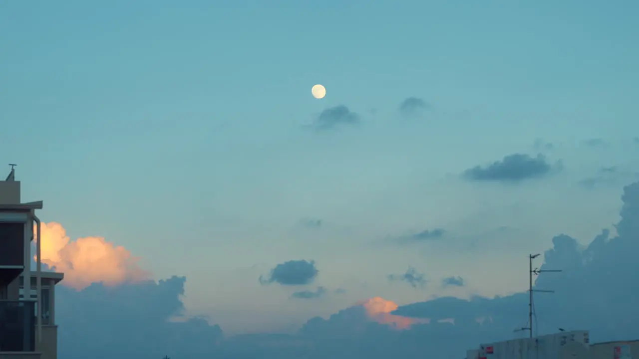 Time lapse of a sunset moon is moving up moving clouds fast motion 4K