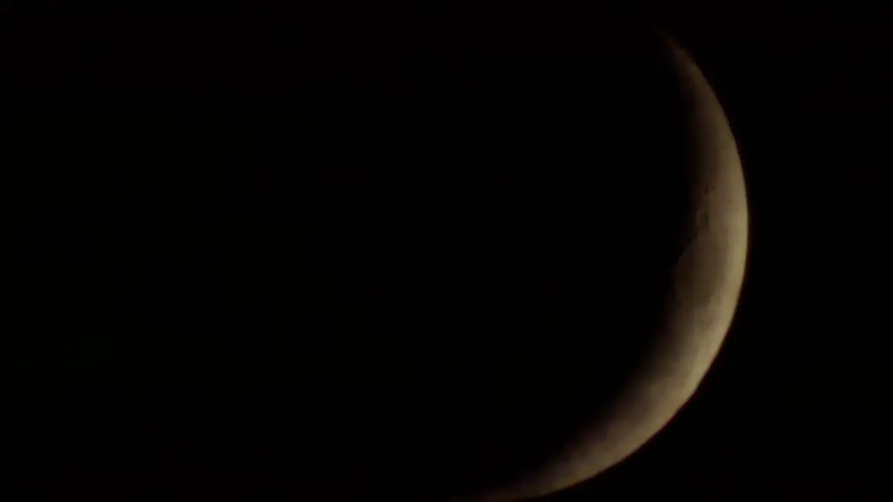 Dark dramatic illuminated moon with fast moving clouds passing across