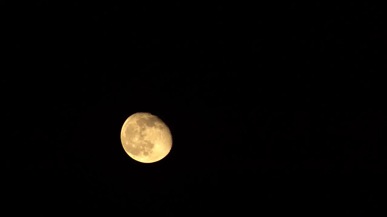 Time-Lapse of Moon rising from bottom left corner of frame to top right frame on dark background