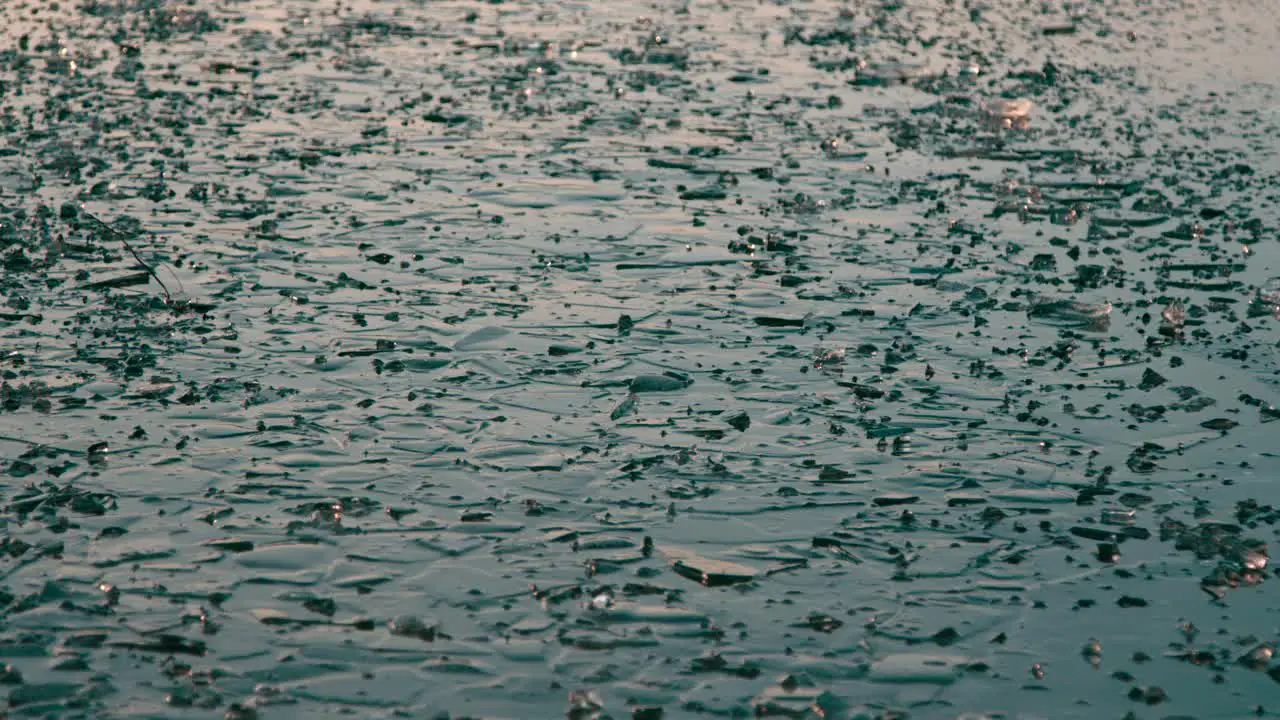 Ice floating on top of waves of moving water on a frozen lake