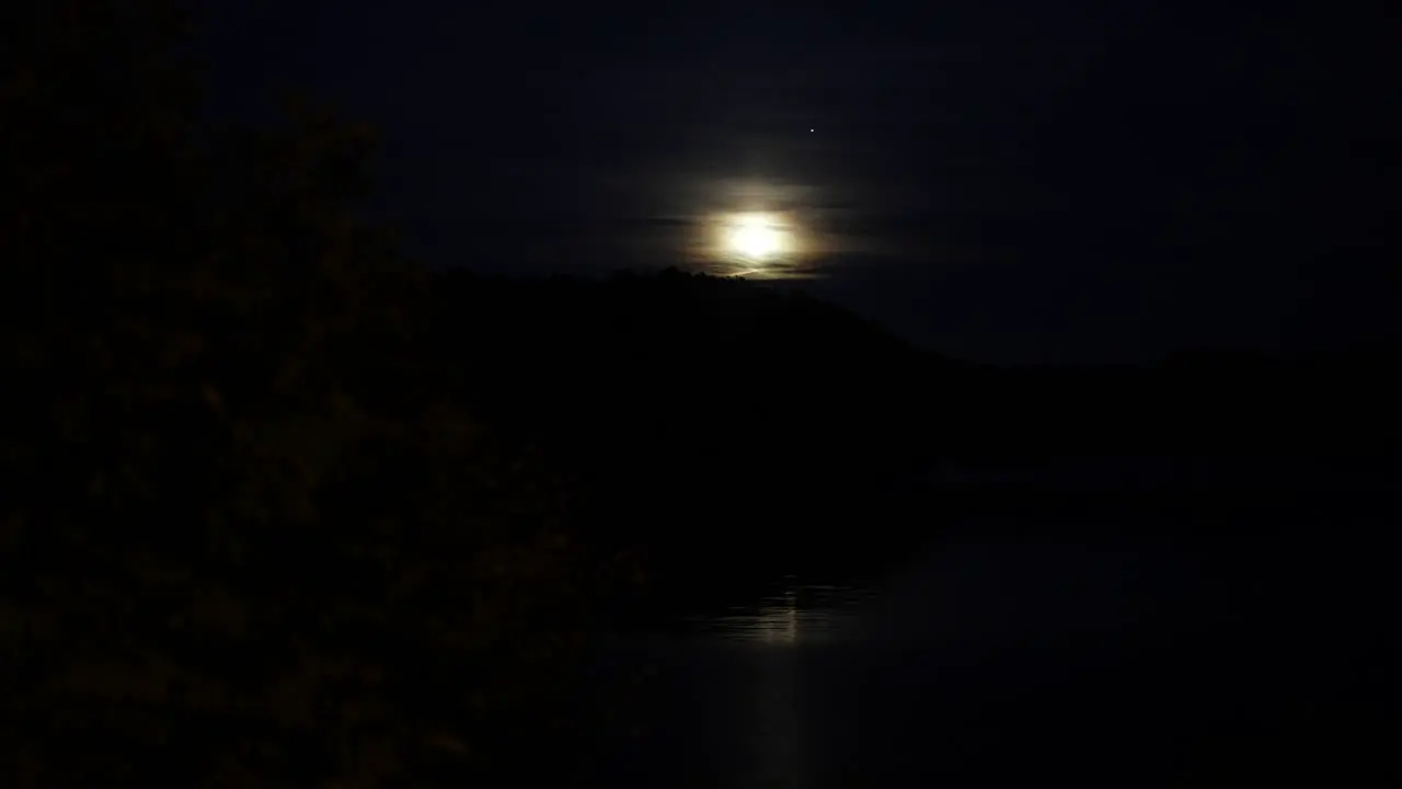 Bright moon rising over hills in Norway