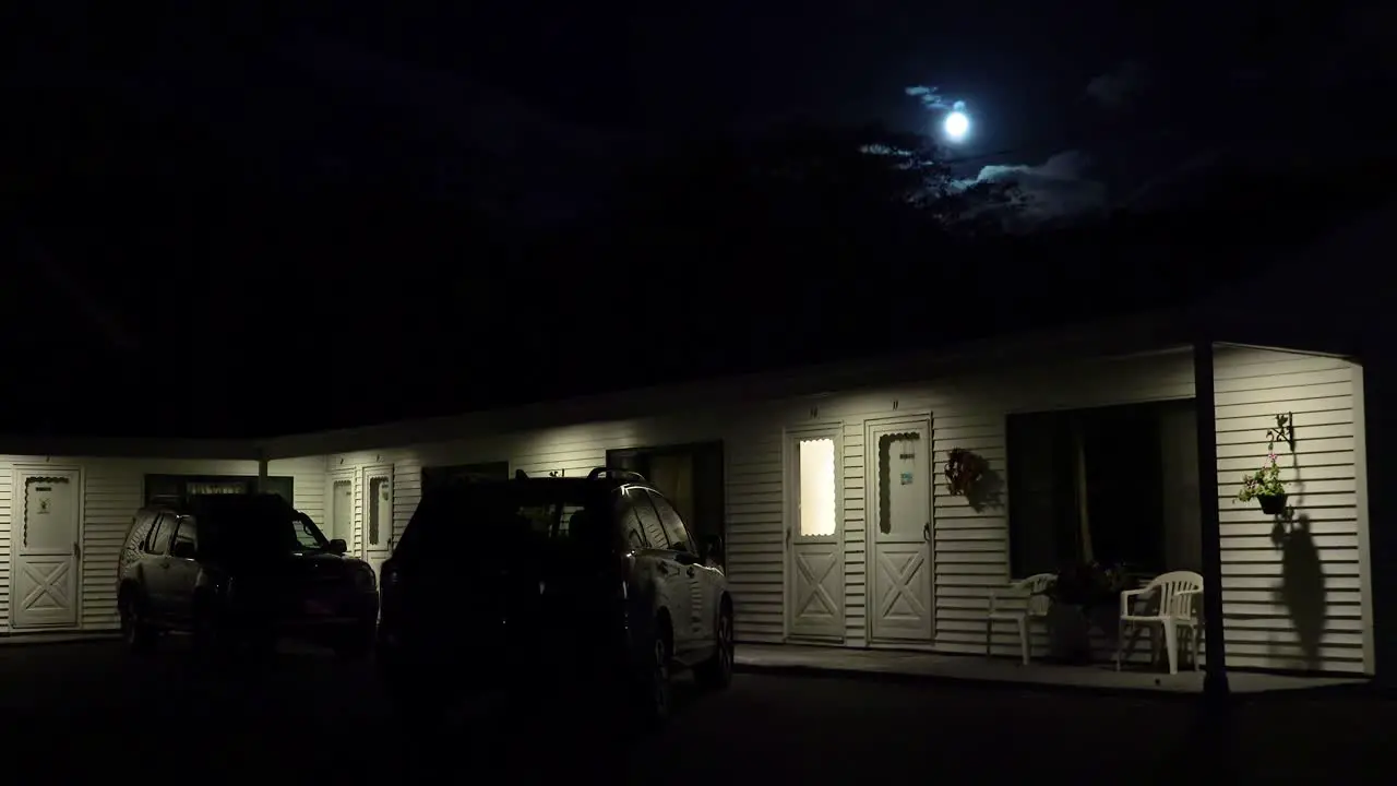 Establishing shot of a roadside motel under a full moon at night