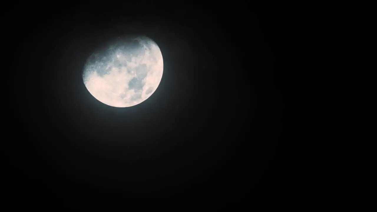 Timelapse of the moon descending behind fast passing clouds