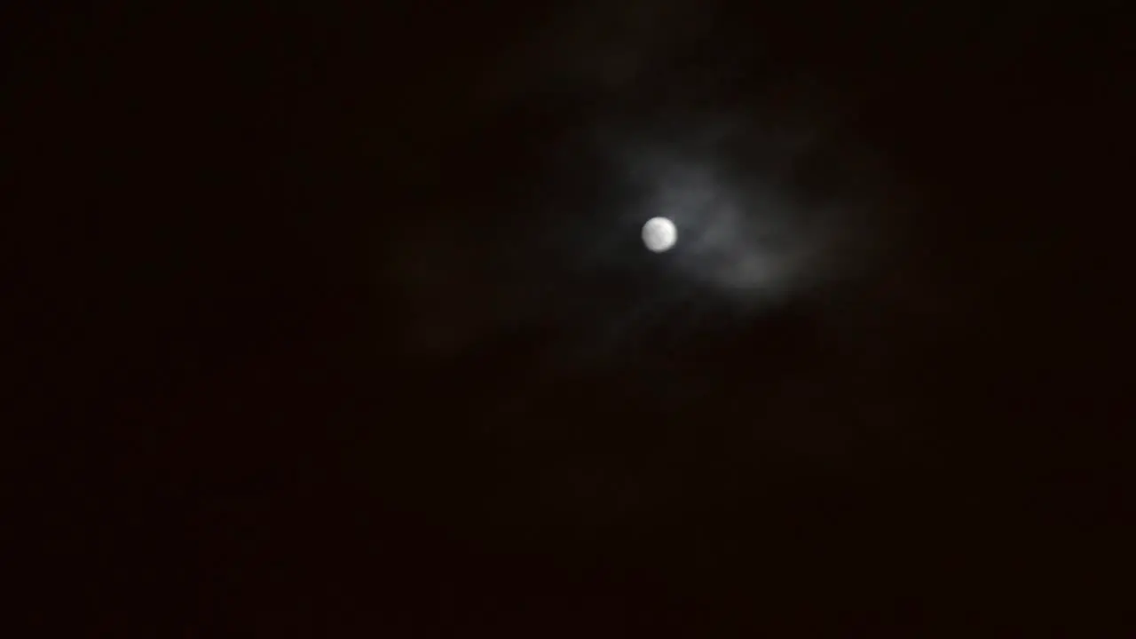 moon moving in and out of the clouds on a late evening where the weather is mysteriously changing to the creepy howls of an enchanted glowing where witches goblins and vampires lurk for their prey