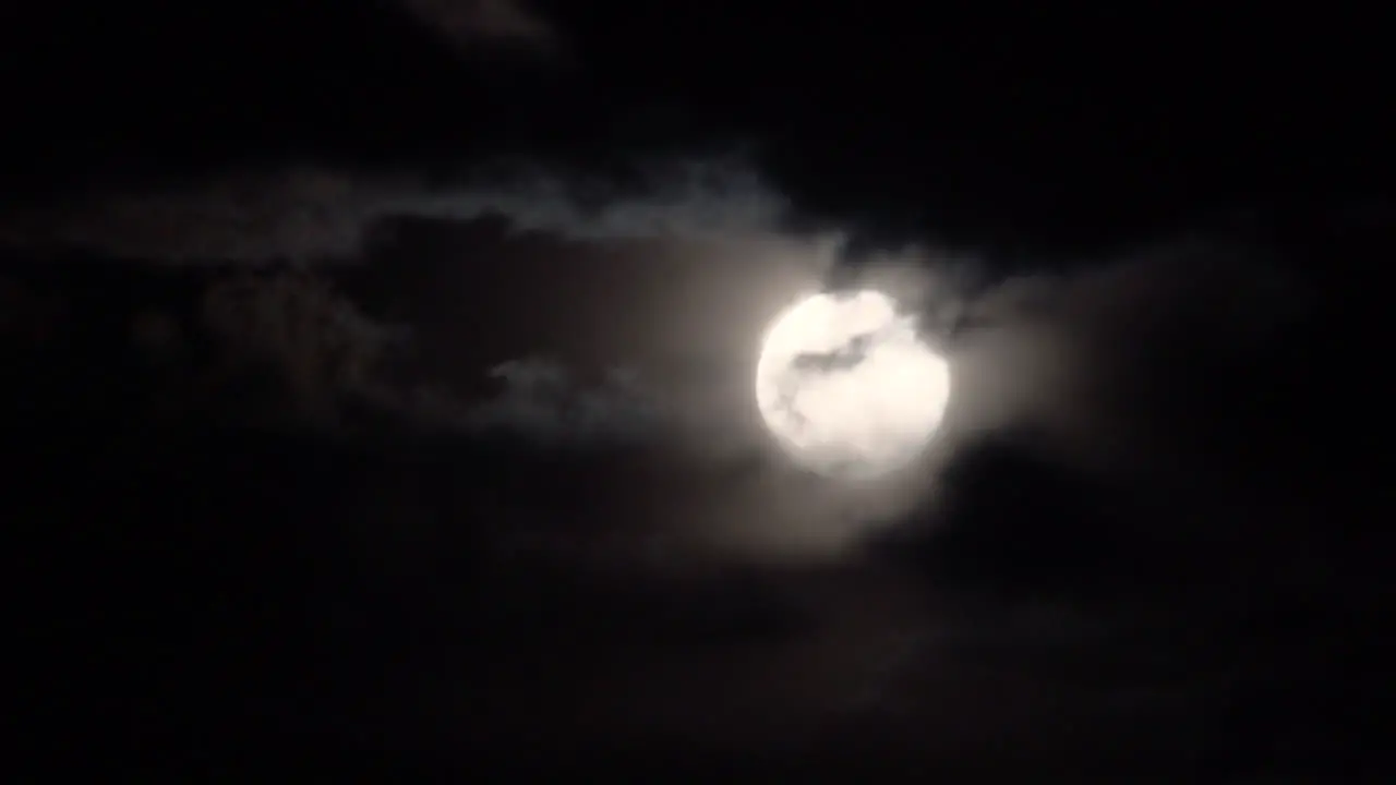 Full moon with spooky clouds passing in front on a dark night