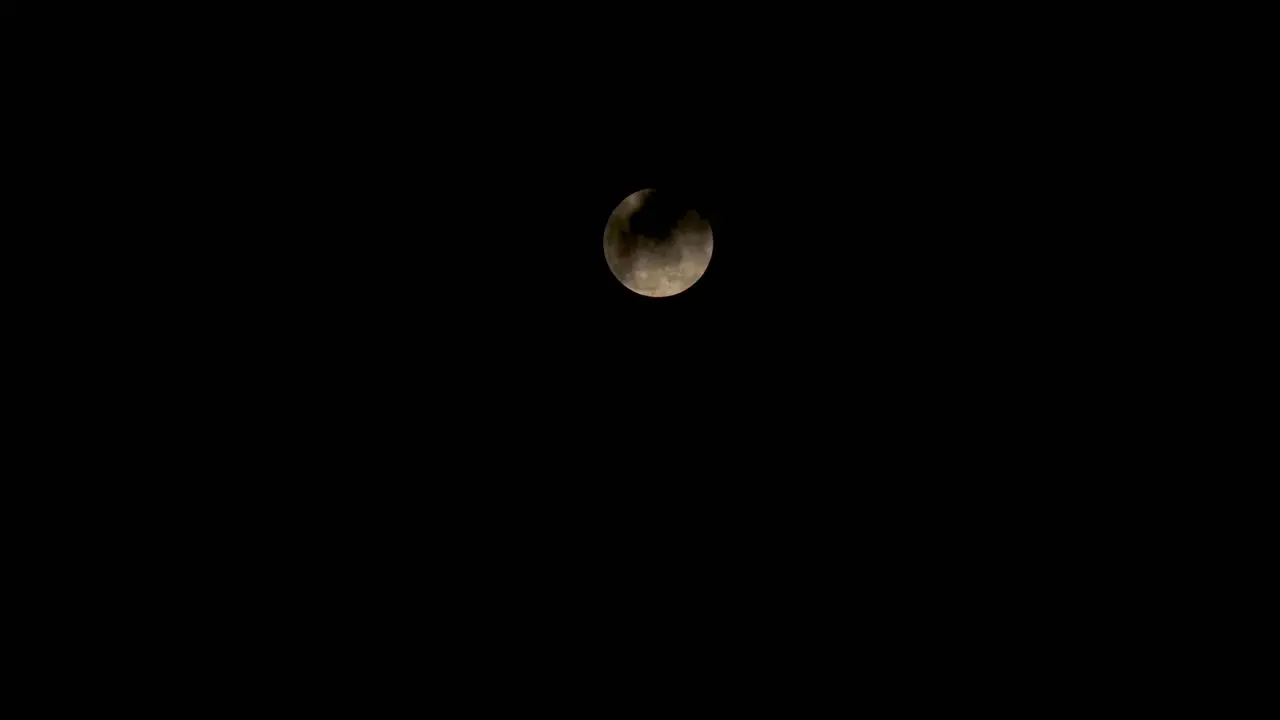 Time lapes during the red moon when it is in full form with slightly clouds obscuring the moon