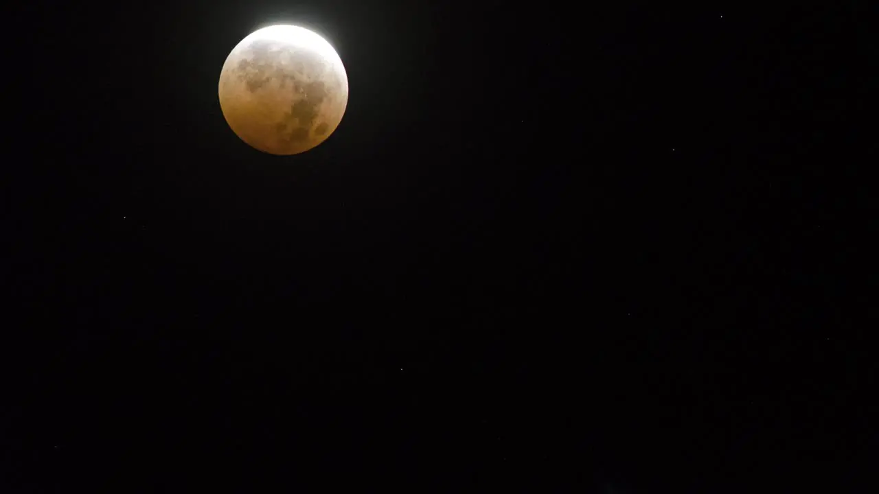 Time lapse of the moon setting across a darkened sky