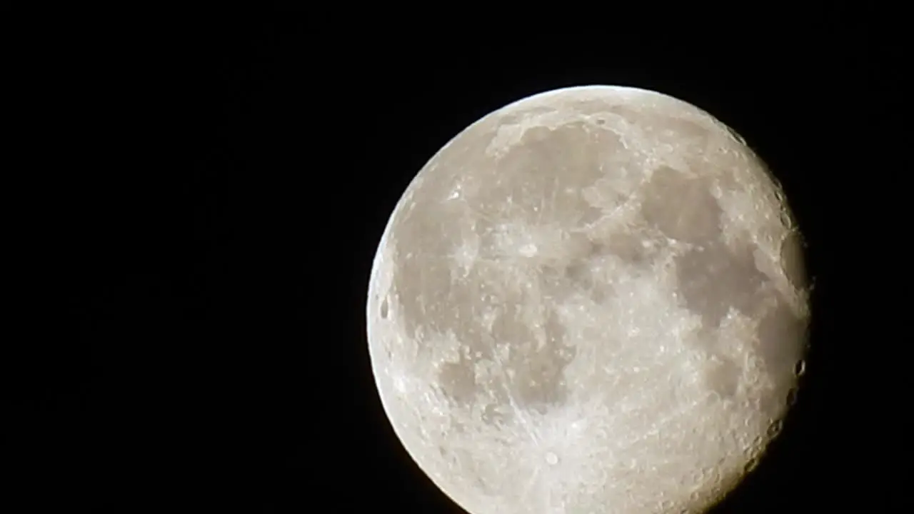 Glowing full moon dramatic night moody sky clouds passing detailed moon crater surface