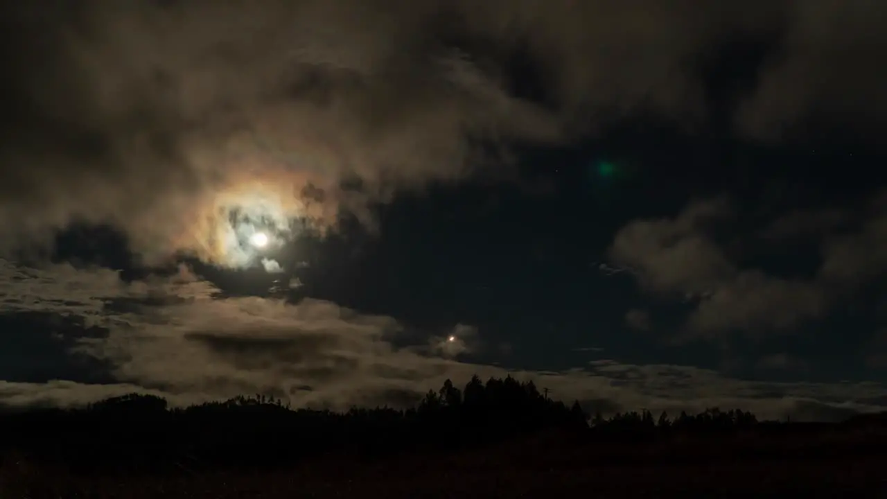 Bright full moon in night sky with clouds passing by timelapse