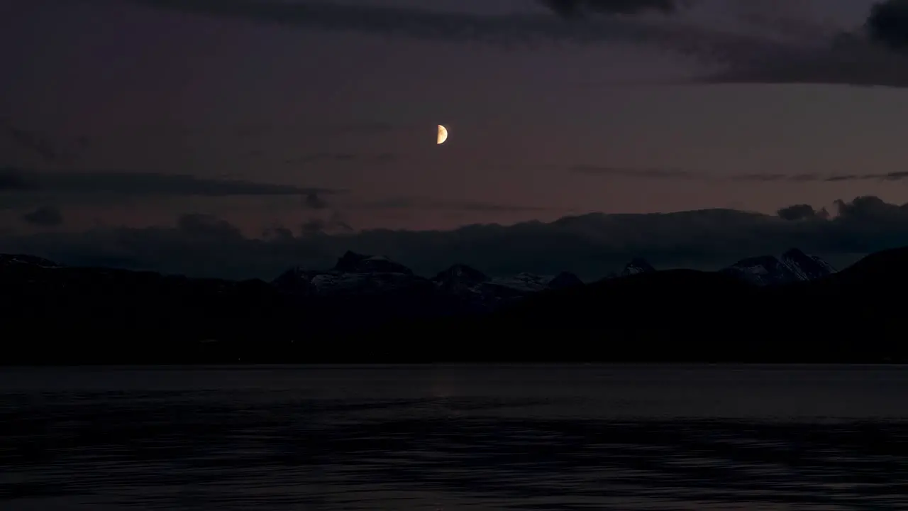 Beautiful time lapse of the moon watching over sea and mountain view