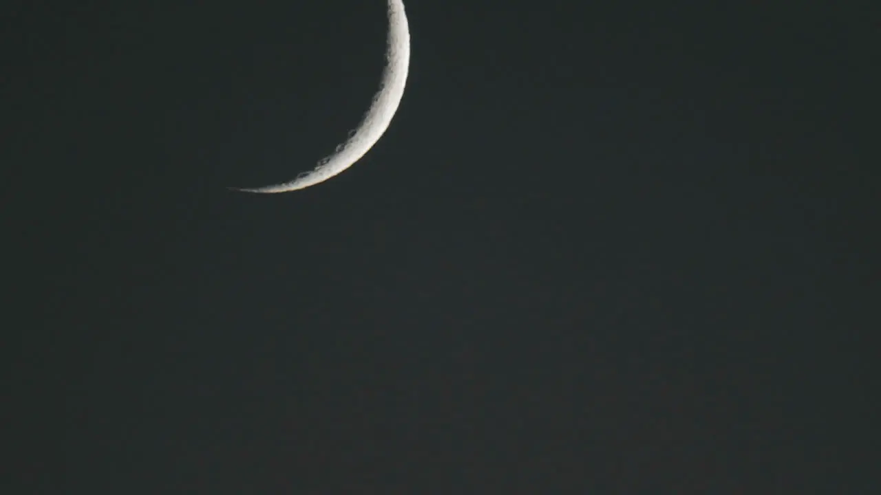 Closeup time lapse of waxing crescent moon setting above Oak View California