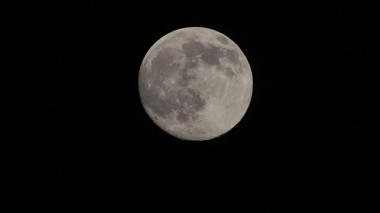 Full moon moves quickly in the dark sky