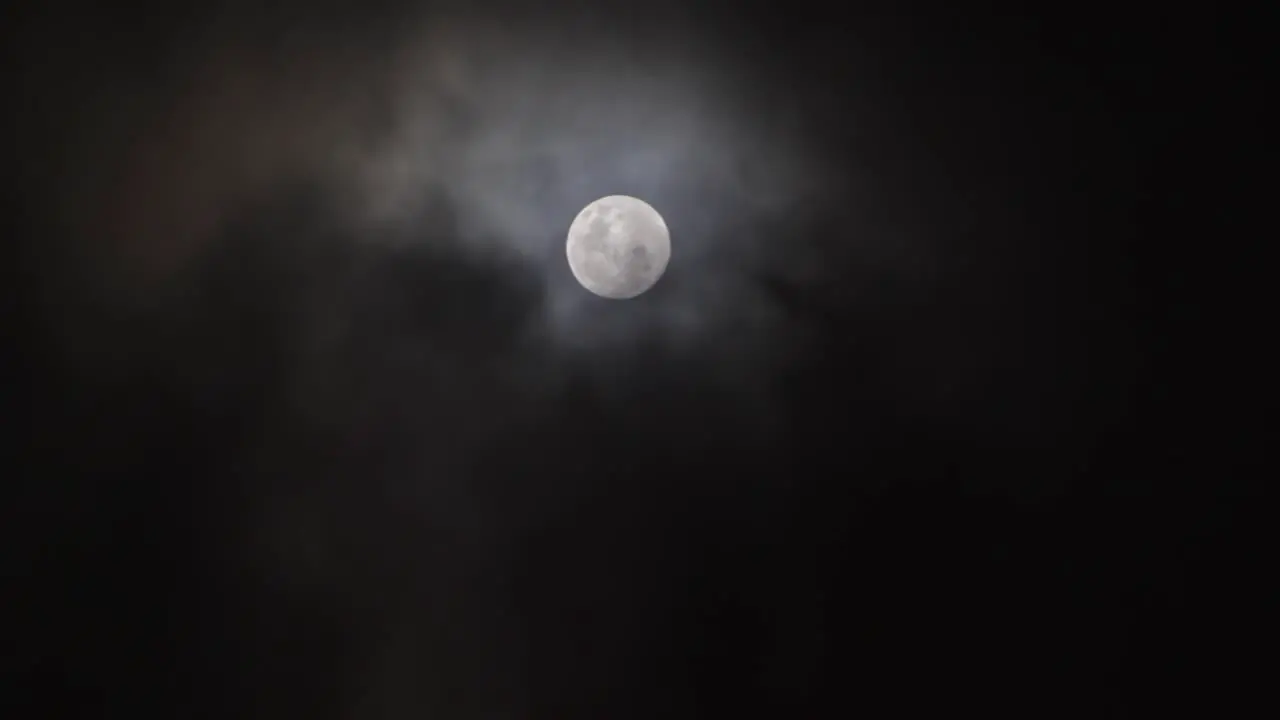 Clouds pass in front of Full Moon in a dark sky 2