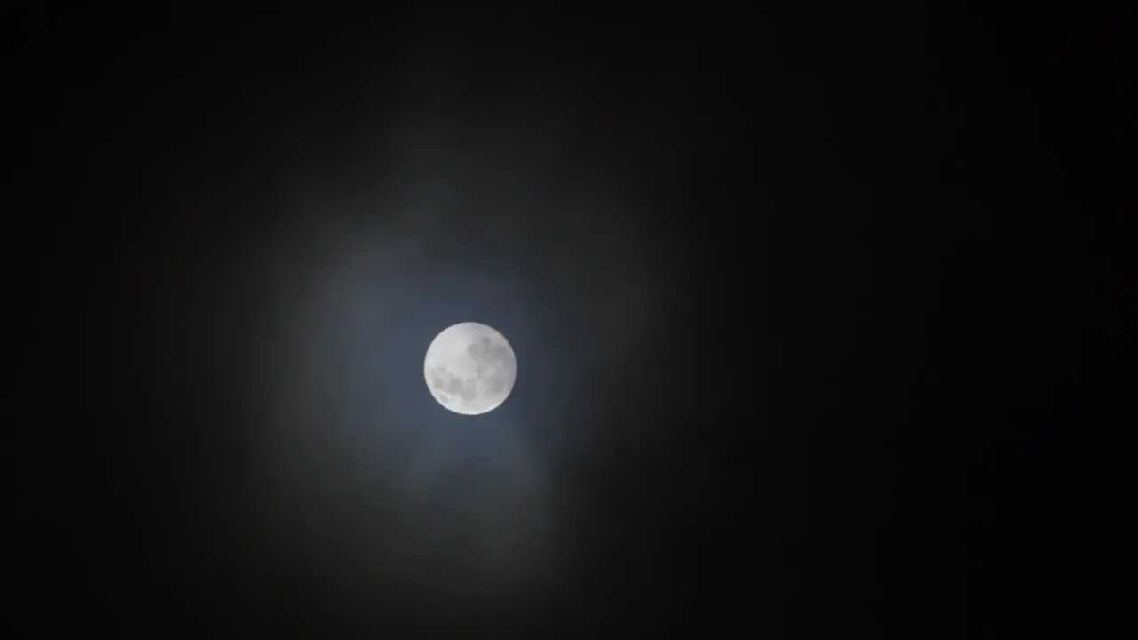 Clouds pass in front of Full Moon in a dark sky 1