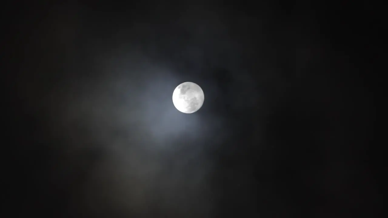 Clouds pass in front of Full Moon in a dark sky 3