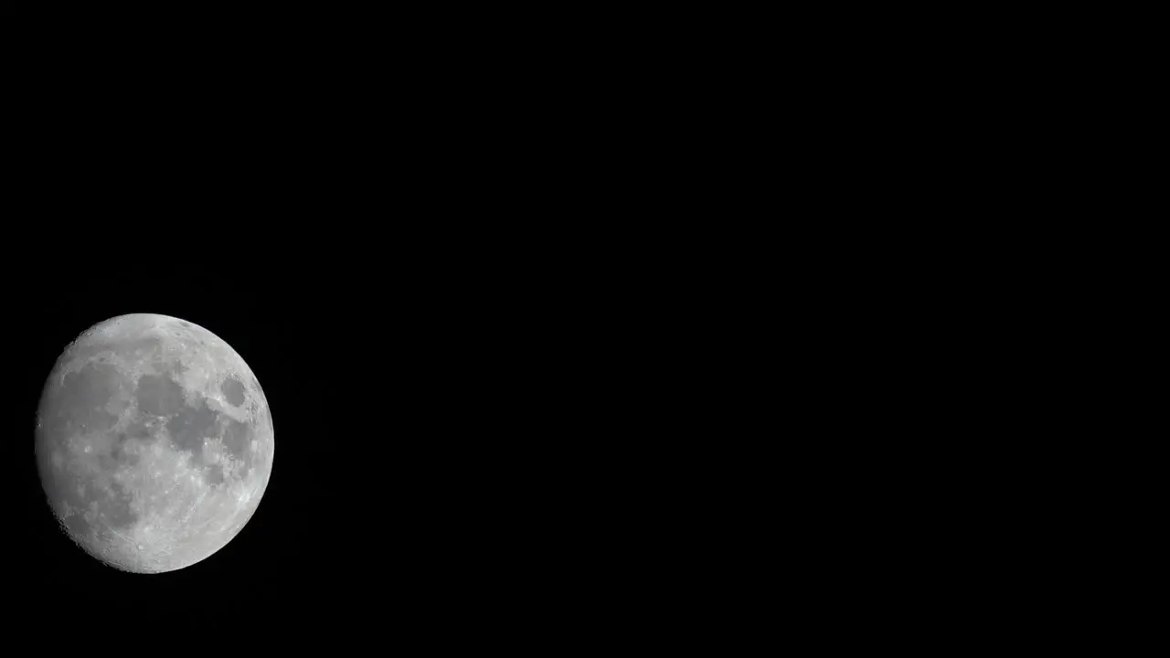 A time-lapse of the moon floating through he black of the night sky