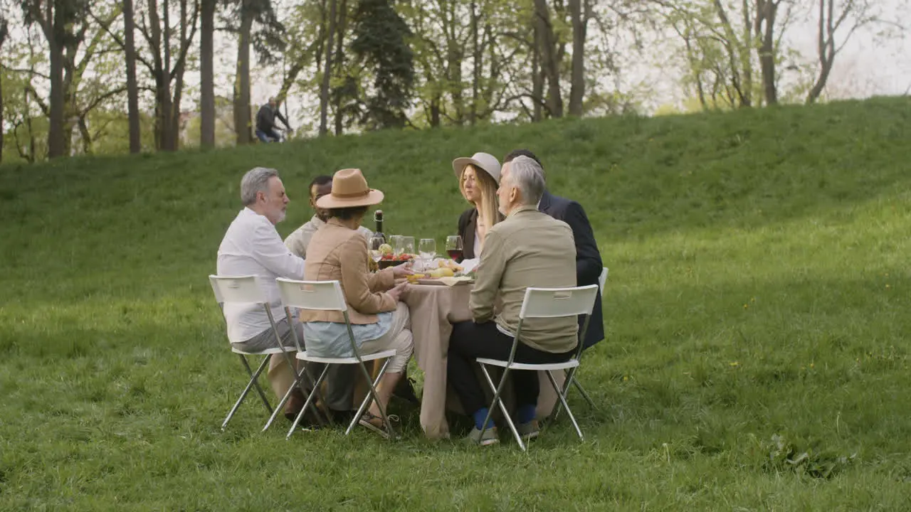 Multirracial Friends Talking Together While Having A Dinner In The Park 1