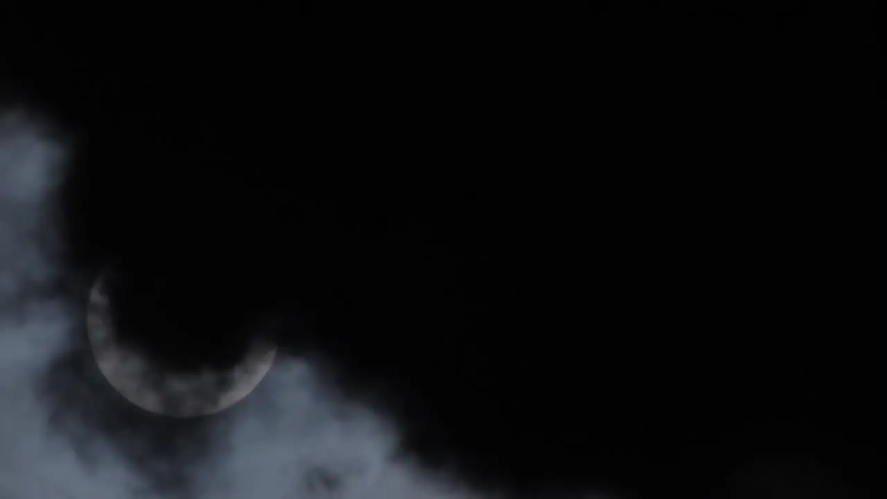 Eclipse of the moon behind the clouds dramatic movie