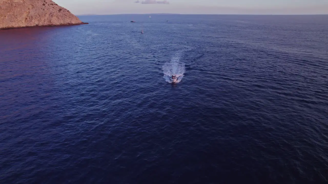 Topshot with Drone while a Boat is driving towards the camera on the ocean