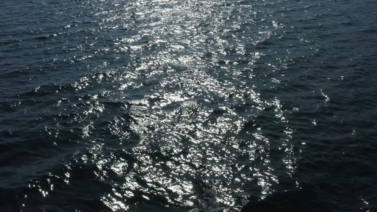 Water surface with reflections of the sun on small waves in the ocean