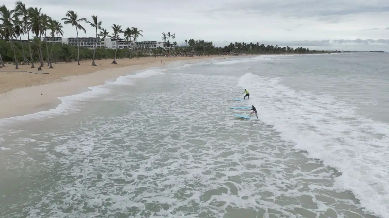 AERIAL Drone shot of surfing lessons at the beach