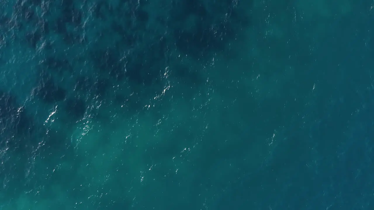 Aerial View Of Wavy Blue Ocean With Visible Coral Reefs In An island In Philippines